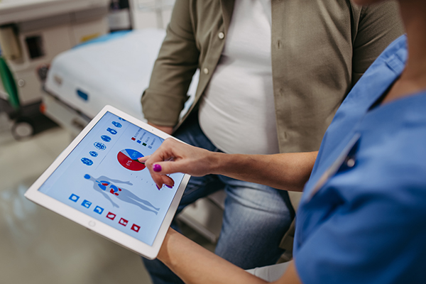 Close up of doctor consulting with the overweight patient, discussing test result in doctor office.