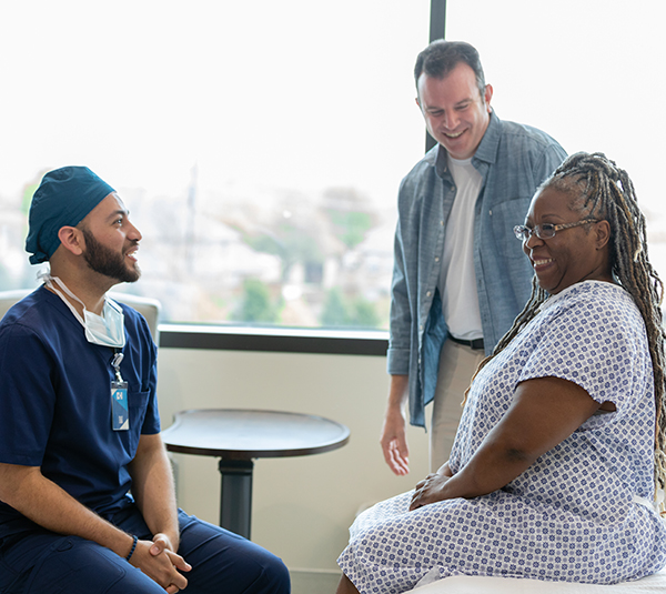 Smiling patient with doctor and family member. Positive healthcare setting.